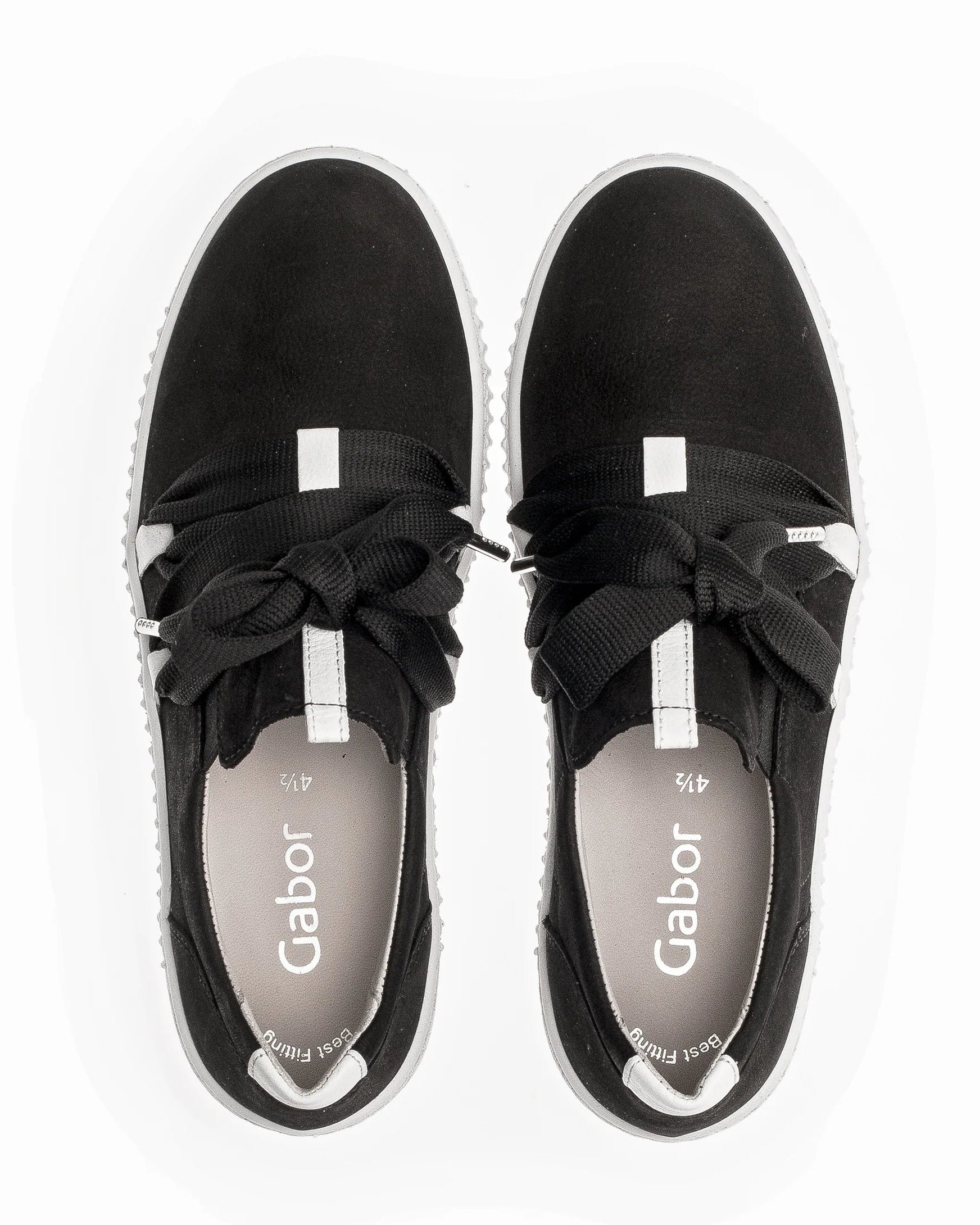 A pair of black slip-on sneakers with wide black laces tied in bows, white side stripes, and a white sole, shown from a top-down view on a white background. The insole displays the brand name 'Gabor'.