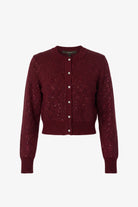 A cropped, long-sleeve knit cardigan in deep burgundy with a textured, sparkly knit pattern and a button-up front, shown against a plain white background.