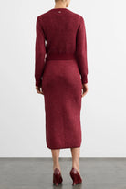 A model viewed from the back wearing a long-sleeve, crew-neck knit midi dress in a heathered burgundy red color, paired with matching burgundy high heels against a light gray studio background.